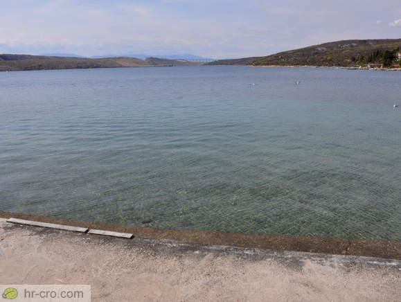 Plaža s pogledom na most na otok Krk